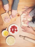 Cucinando con i bambini Le mani della madre e del bambino impastano e rotolano dou fotografia stock Cucinando con i bambini Le mani della madre e del bambino impastano e rotolano dou fotografia stock