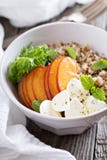 Cuenco de la quinoa con el melocotón y el mozarella Imagen de archivo Cuenco de la quinoa con el melocotón y el mozarella Imagen de archivo