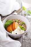Cuenco de la quinoa con el melocotón y el mozarella Imágenes de archivo libres de regalías Cuenco de la quinoa con el melocotón y el mozarella Imágenes de archivo libres de regalías