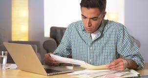 Cuentas que pagan del hombre hispánico en casa imagen de archivo Cuentas que pagan del hombre hispánico en casa imagen de archivo