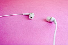 Cuffie bianche di bello vuoto di plastica digitale moderno con i cavi per ascoltare la musica su un fondo rosa porpora Copi lo sp immagine stock Cuffie bianche di bello vuoto di plastica digitale moderno con i cavi per ascoltare la musica su un fondo rosa porpora Copi lo sp immagine stock
