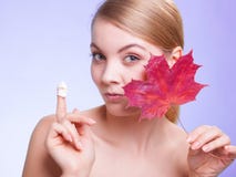 Cuidado de piel Cara de la muchacha de la mujer joven con la hoja de arce roja Foto de archivo libre de regalías Cuidado de piel Cara de la muchacha de la mujer joven con la hoja de arce roja Foto de archivo libre de regalías