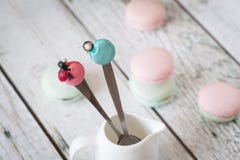 Cuillères drôles avec des macarons et des coccinelles photo stock Cuillères drôles avec des macarons et des coccinelles photo stock