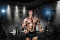 Culturista muscolare dell'atleta nell'addestramento della palestra con la barra immagini stock Culturista muscolare dell'atleta nell'addestramento della palestra con la barra immagini stock