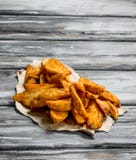 Cunhas cozidas da batata no papel fotos de stock Cunhas cozidas da batata no papel fotos de stock