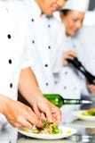 Cuoco unico asiatico nella cottura della cucina del ristorante fotografie stock libere da diritti Cuoco unico asiatico nella cottura della cucina del ristorante fotografie stock libere da diritti