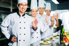 Cuoco unico asiatico nella cottura della cucina del ristorante immagine stock libera da diritti Cuoco unico asiatico nella cottura della cucina del ristorante immagine stock libera da diritti