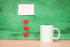 Cuore e tazza su un fondo verde fotografie stock Cuore e tazza su un fondo verde fotografie stock