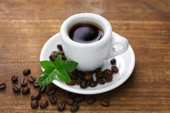 A cup of black coffee with roasted coffee beans and leaves stock images A cup of black coffee with roasted coffee beans and leaves stock images