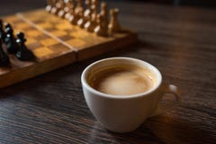 Cup of coffee and chess-board in a prospect on a wooden table royalty free stock photo Cup of coffee and chess-board in a prospect on a wooden table royalty free stock photo
