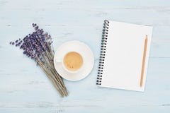 Cup of coffee, empty notebook and lavender flower on blue table top view. Woman working desk. Cozy breakfast. Flat lay style. Royalty Free Stock Photos Cup of coffee, empty notebook and lavender flower on blue table top view. Woman working desk. Cozy breakfast. Flat lay style. Royalty Free Stock Photos