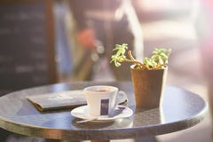 Cup of coffee on table beside plant Stock Photos Cup of coffee on table beside plant Stock Photos