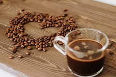 Cup of coffee on a tray and coffee beans in the shape of a heart stock photo Cup of coffee on a tray and coffee beans in the shape of a heart stock photo