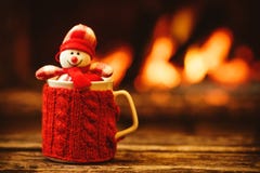 Cup of hot drink in front of warm fireplace. Holiday Christmas
