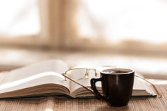 Cup Of Coffee, Standing Next To An Open Book Stock Photos