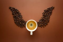 Cup Of Espresso With Wings From Coffee Beans On Brown Background. Good Morning Concept. Top View. Flat Lay. Royalty Free Stock Photos