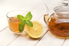 Cup of tea, glass teapot, mint and lemon on stock image Cup of tea, glass teapot, mint and lemon on stock image