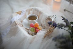 Cup of tea and marmalade in a jar lay in the cart covered with a white silk cloth royalty free stock image Cup of tea and marmalade in a jar lay in the cart covered with a white silk cloth royalty free stock image