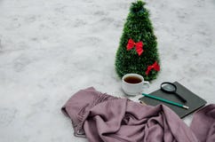 A cup of tea, a scarf, a magnifying glass, a pencil, a notebook and a small artificial Christmas tree stock photography A cup of tea, a scarf, a magnifying glass, a pencil, a notebook and a small artificial Christmas tree stock photography