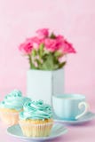 Cupcake With Sweet Mint Cream Decoration And Bouquet Of Red Roses In Retro Shabby Chic Vase On Pink Pastel Background. Stock Image