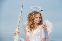 Cupido del d?a de tarjetas del d?a de San Valent?n Muchacha inocente con las alas del ?ngel que se oponen con el arco y la flecha imagen de archivo Cupido del d?a de tarjetas del d?a de San Valent?n Muchacha inocente con las alas del ?ngel que se oponen con el arco y la flecha imagen de archivo