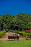 CURITIBA ,BRAZIL - MAY 12, 2016: people resting on a bench at the geometrical gardens of the botanical park of the city Stock Photography CURITIBA ,BRAZIL - MAY 12, 2016: people resting on a bench at the geometrical gardens of the botanical park of the city Stock Photography