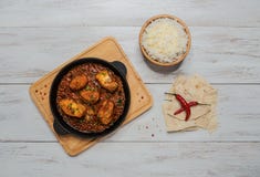 Curry del pesce del bengalese e mettere le spezie indiane con riso basmati sulla tavola di legno immagini stock Curry del pesce del bengalese e mettere le spezie indiane con riso basmati sulla tavola di legno immagini stock
