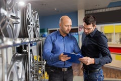 Customer and salesman at car service or auto store royalty free stock image Customer and salesman at car service or auto store royalty free stock image