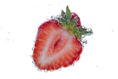 Cut strawberry with bubbles stock image Cut strawberry with bubbles stock image