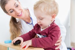 Cute active baby boy playing with toys during physical examination royalty free stock photo Cute active baby boy playing with toys during physical examination royalty free stock photo