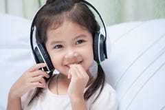 Cute asian child girl in headphones listening the music royalty free stock image Cute asian child girl in headphones listening the music royalty free stock image