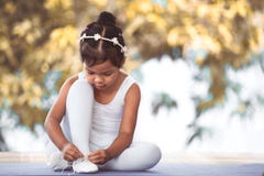 Cute asian child girl tying on feet pointe shoes Royalty Free Stock Image Cute asian child girl tying on feet pointe shoes Royalty Free Stock Image