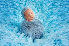 Cute Baby Boy, Peacefully Sleeping Wrapped In Blue Wrap On A Blu Royalty Free Stock Image