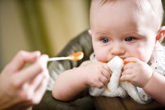 Cute baby eating solid food from a spoon