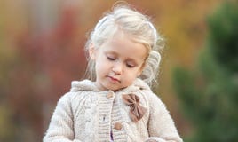 Cute baby girl looking thoughtfully down on a colorful background. Close-up stock images Cute baby girl looking thoughtfully down on a colorful background. Close-up stock images