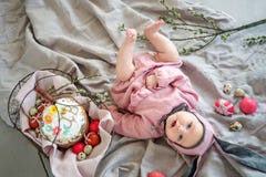 Baby lying on linen blanket and wearing a hat in the form of a Easter bunny with eggs willow branches and Easter pie stock photography Baby lying on linen blanket and wearing a hat in the form of a Easter bunny with eggs willow branches and Easter pie stock photography