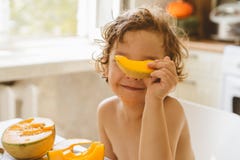 Cute Beautiful Little Boy Eating Fresh Melon. Stock Photo Cute Beautiful Little Boy Eating Fresh Melon. Stock Photo