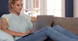 Cute blonde using laptop on couch