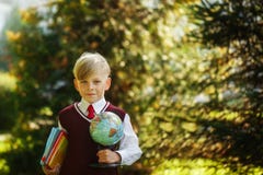 Cute boy going back to school. Child with books and globe on first school day stock photo Cute boy going back to school. Child with books and globe on first school day stock photo