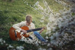 Cute boy making music playing the guitar on nature. Stock Images Cute boy making music playing the guitar on nature. Stock Images