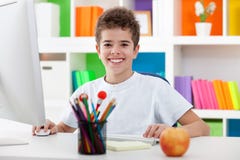 Cute boy using a computer and smiling stock images Cute boy using a computer and smiling stock images