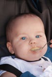 Cute caucasian baby boy fed from small spoon in baby chair. Close up portrait of pretty baby with bright blue eyes. stock photos Cute caucasian baby boy fed from small spoon in baby chair. Close up portrait of pretty baby with bright blue eyes. stock photos