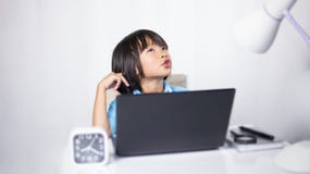 Cute Child Thinking And Typing Laptop. Stock Photos