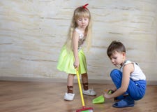 Cute children using toy broom and dustpan Stock Image Cute children using toy broom and dustpan Stock Image