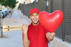 Cute ethnic pizza delivery guy holding heart shaped balloon stock image Cute ethnic pizza delivery guy holding heart shaped balloon stock image