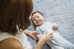 Cute happy girl holding her newborn baby brother. Gray background. Pretty baby boy in blue clothes royalty free stock images Cute happy girl holding her newborn baby brother. Gray background. Pretty baby boy in blue clothes royalty free stock images