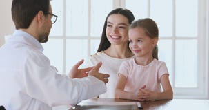 Cute healthy little girl patient listening male doctor at consultation