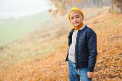 Cute Kid Boy On A Walk In Autumn. Kids Fashion Concept. Autumn Mood. Happy Boy In Autumn Park. Boy Wearing Header And Jacket. Royalty Free Stock Images Cute Kid Boy On A Walk In Autumn. Kids Fashion Concept. Autumn Mood. Happy Boy In Autumn Park. Boy Wearing Header And Jacket. Royalty Free Stock Images