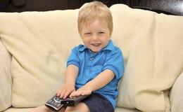 Cute Kid Watching Tv, Sitting In Chair Stock Photo