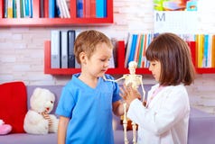 Cute kids playing in doctors with toy human skeleton stock photos Cute kids playing in doctors with toy human skeleton stock photos
